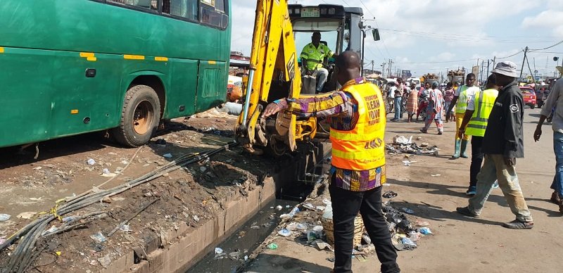 An excavator dredging a gutter at Agboglboshie