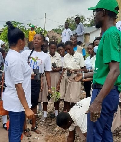 Mr Emmanuel Kyere (right) supervising a pupil to plant tree seedlings.