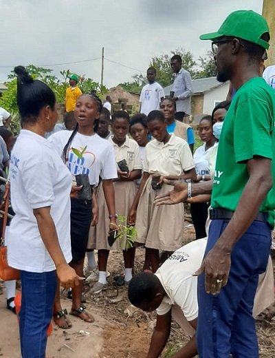 Mr Emmanuel Kyere (right) supervising a pupil to plant tree seedlings.