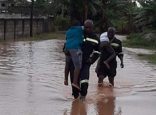 • Rescue team of the Fire Service carrying children through the floods