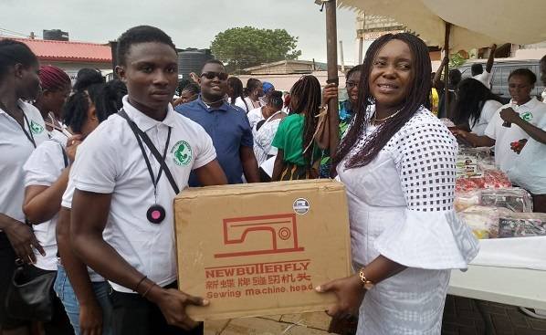 Ms Sowah (right) presenting a sewing machine to one of the graduands