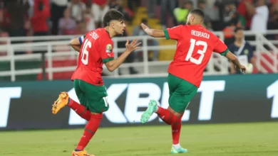 Morocco players celebrate the late win over Guinea in the opening match