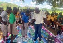 Mr Baabu demonstrating to some school children how the board game is played