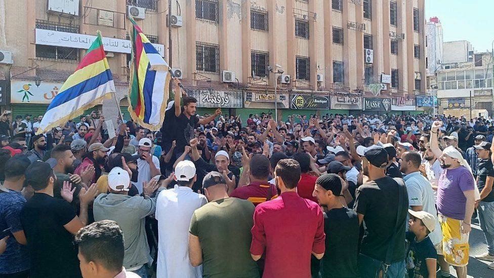 • A photo from activist collective, Suwayda24, showed protesters waving Druze flags in Suweida's al-Sayr square on Tuesday