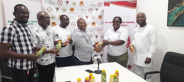 • Madam Roseline Acheampong (second right) presenting the drinks to Mr Boadi-Mensah