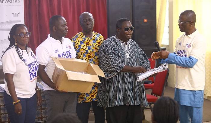 • Dr Obeng-Asamoa receiving the white canes from the lecturer