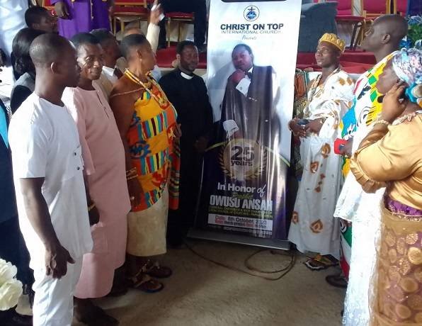 Prophet Ansah being assisted to unveil the anniversary logo