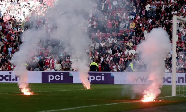 Fire flares on the pitch during the game .