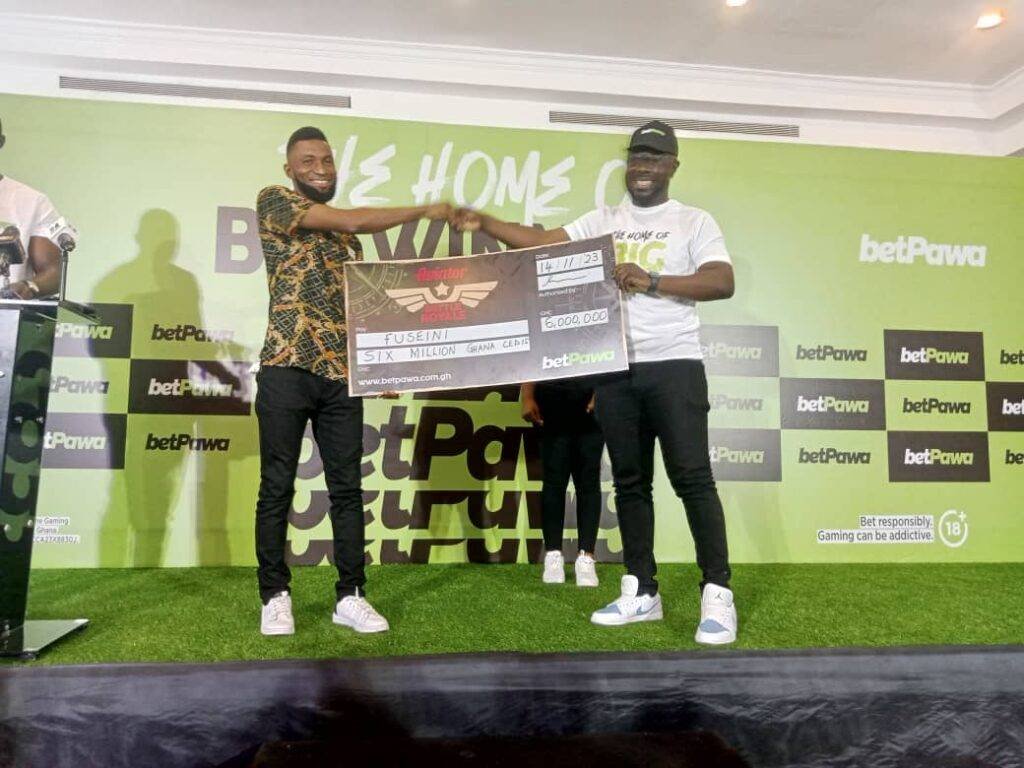 Proud winner Fuseni(left) receiving his dummy cheque from Mr Badu