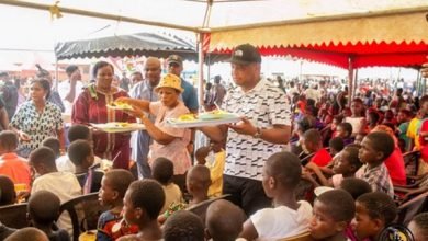• Mr Ablakwah (right) serving some of the children with food