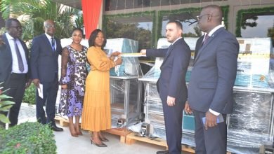 • Mrs Botchwey (fourth from left) being assisted by Mr Jaafar to cut the tape and officially receive the printers. With them are Mr Paul Kwame Cudjoe (right) and other dignitaries Photo: Victor A. Buxton
