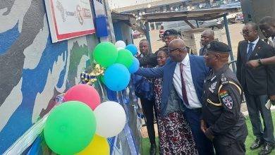 Ms Naana Eyiah Quansah, (middle) being assisted by Mr Samuel Williams Yeboah and COP Yohonu to cut the tape open the refurbished armouries