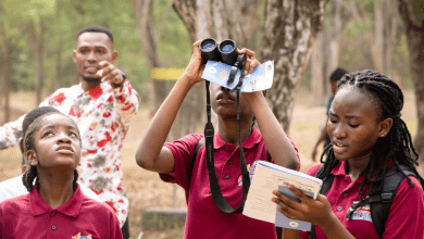 Birdwatching and notes taking by school children at event.