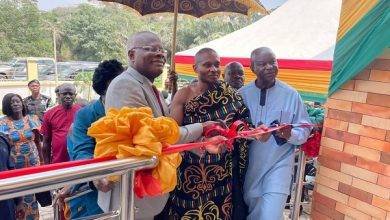 Mr K.T. Hammond cutting the tape with the assistance of other dignitaries to open the facility
