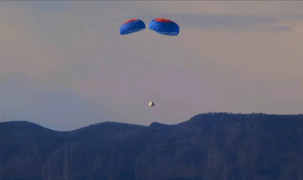 The New Shepard crew capsule descends under parachutes during its launch Tuesday, Dec. 19, 2023. Photo Credit: Blue Origin