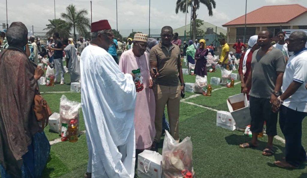 Sheikh Ibrahim (in white gown) presenting to a beneficiary