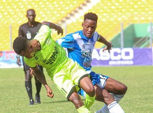 • Bechem United’s Emmanuel Annor (in green) trying to go past Raymond Oko Grippman of Olympics in Wednesday’s game Photo: Raymond Ackumey