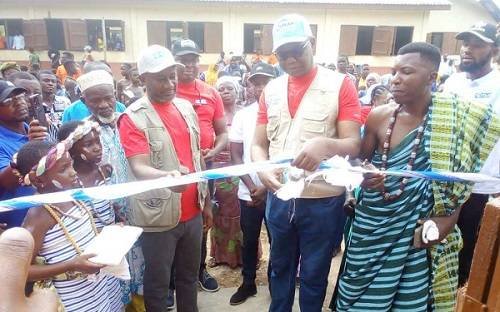 Mr Solomon Tesfamariam (middle) assisted by Traditional Elders to cut tape to inaugurate the facility