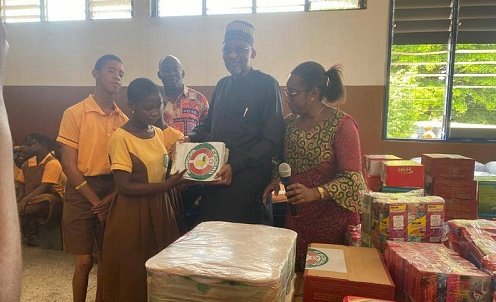 Baba Wikil presenting the items to one of the students