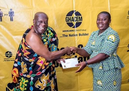 Ehunabobrim Prah Agyensaim VI (left) handing over cement chit to a beneficiary