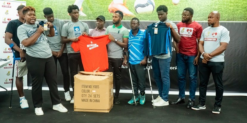 • Jed Akwaboah presenting one of the jerseys to Bawa Mohammed, leader of the Asanteman SC, while others look on