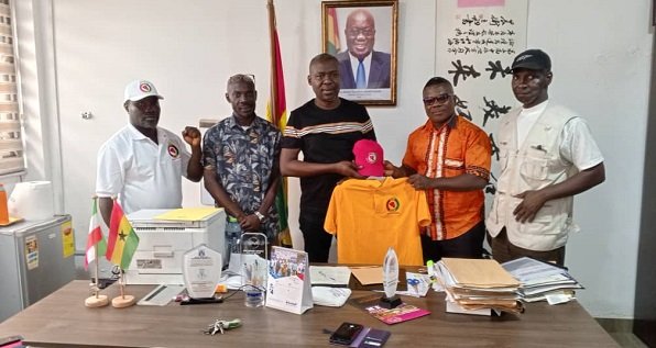 Mr Ernest Arthur (middle) receiving a Lacoste from the Mr Kingsley Arthur