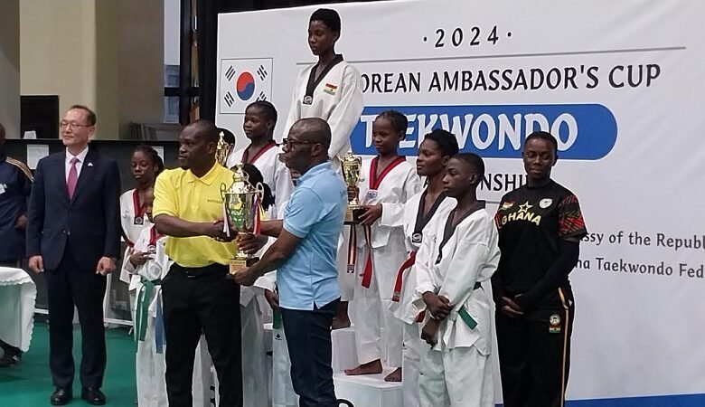 Mr Lartey Otu presenting the trophy to the Greater Accra team while Mr Park Kyongsig (in suit) and others looking on