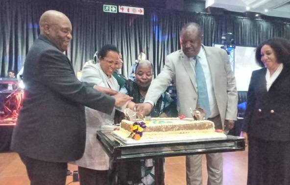 • Ms Mongella (middle) being assisted by Mr Charumbira (second right) and Clerk ( right) to cut the anniversary cake