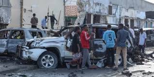 • A group of people look at the debris and destruction at a cafe in Mog