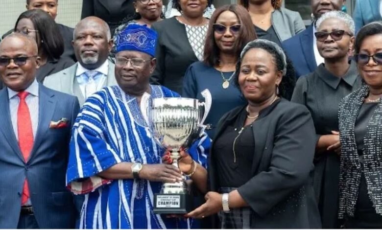 • Mr Cletus Avoka presenting the trophy to Justice Gertrude Torkonoo. Looking on are members of the judicial service and organisers of the match