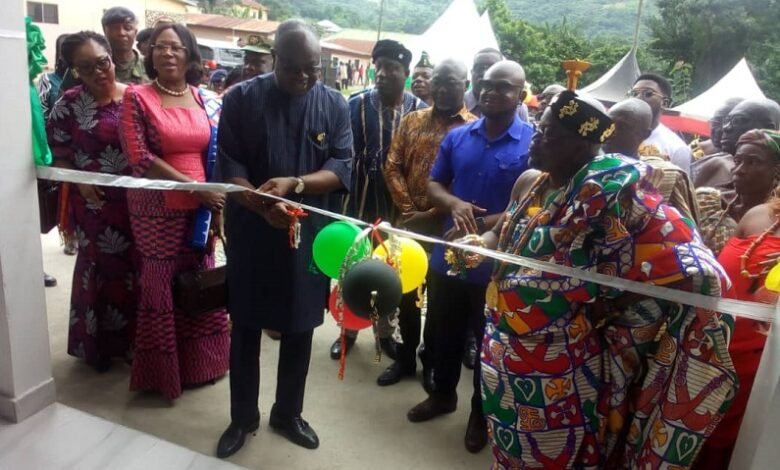 Mr Kwaku Ampratwum-Sarpong (second from left) being assisted by Chief of Leklebi -Kame, Togbe Atatsi V, (right) to cut the tape to open the facility