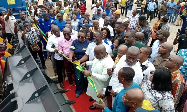 • Mr Seth Acheampong, (middle) cutting the tape to commission and hand over vehicles and machinery to the district assemblies in the Eastern Region