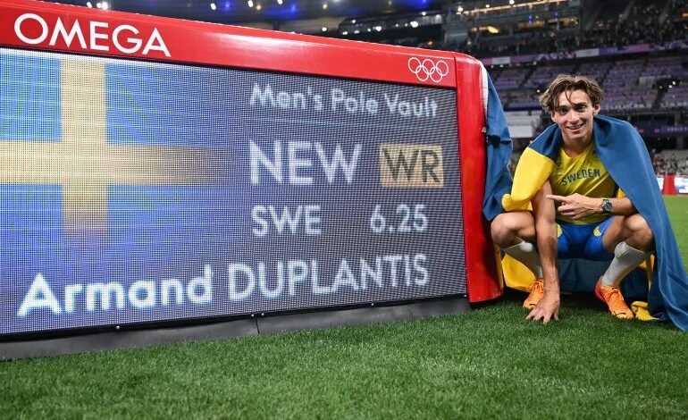 • Duplantis pose with the timer displaying his new record at the Stade de France