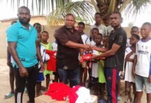 • Soccer for Dreamers Youth Coordinator, Martin MarteyTetteh (right), presenting the items to coach Narwortey