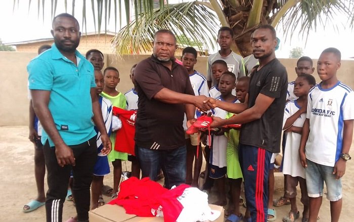 • Soccer for Dreamers Youth Coordinator, Martin MarteyTetteh (right), presenting the items to coach Narwortey