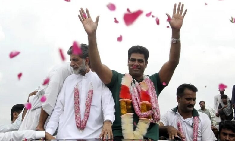 • Men's javelin gold medalist, Arshad Nadeem of Pakistan, centre, waves to people outside his village in Mian Channu, Khanewal district, of Pakistan,