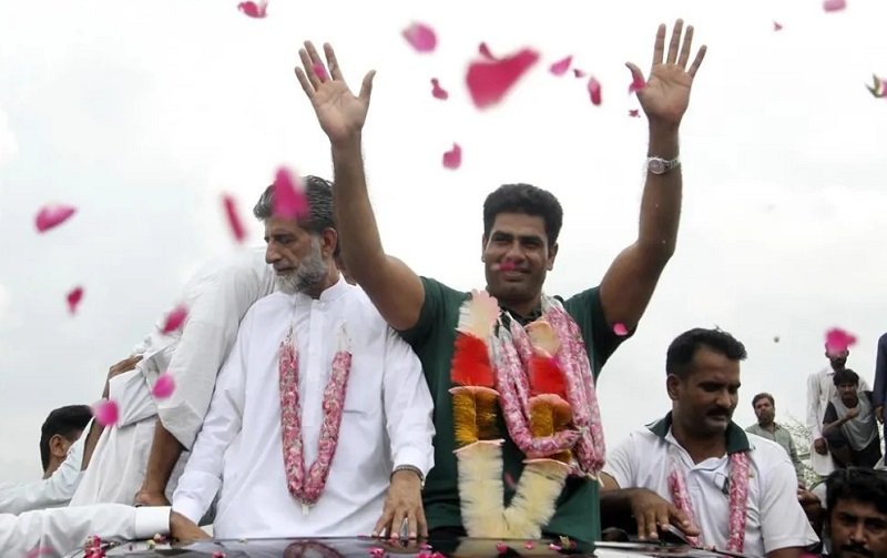 • Men's javelin gold medalist, Arshad Nadeem of Pakistan, centre, waves to people outside his village in Mian Channu, Khanewal district, of Pakistan,