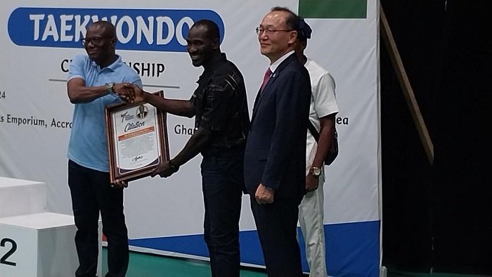 • Mr Lartey Otu (left) receiving the citation from the Vice President of the GTF, Mr Charles Cromwell. Looking on is the Korea Ambassador to Ghana, Mr Park Kyongsig