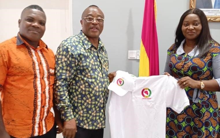 • Mrs Assan (right) receiving the branded T-Shirt from Mr Walker while Mr Arthur (left) looks on