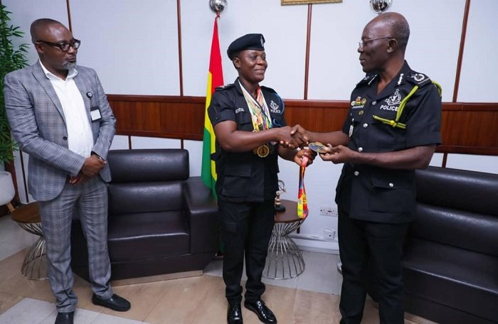 • Ms Minta presenting the medals to Dr Dampare (right). Looking on is Mr Osei Asibey