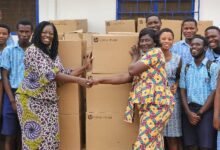 • Ms Bartels (left) presenting the computers to Mrs Barbara Thompson