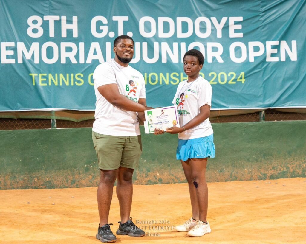 A member of the Oddoye family presenting a certificate to girls U-16 winner, Ayidaama Akaguri