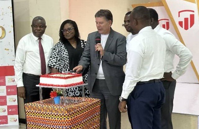 • Mr Heyn (third from left) cutting the cake to celebrate the anniversary