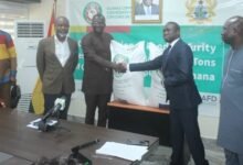 • Mr Ndiane Charles (second from right) handing over the cereals to Dr Acheampong. With them are other dignitaries