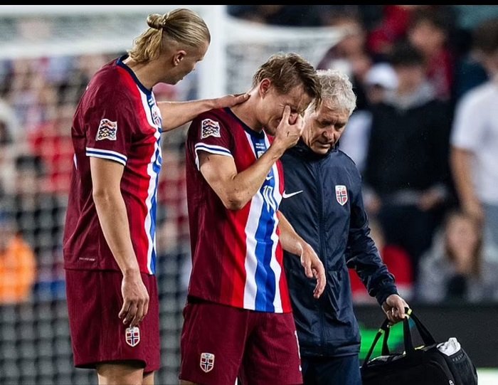 • Martin Odegaard (middle) walking off the pitch after the injury