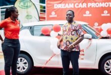 • Mr Nartey standing beside his new car