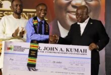 • President Akufo-Addo (right) presenting the cheque to Mr Naamgwinaa (middle)