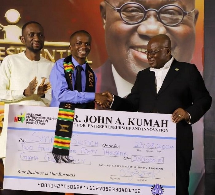 • President Akufo-Addo (right) presenting the cheque to Mr Naamgwinaa (middle)