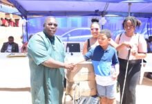 • Master Brayson Roberts (second from right) presenting boxes of white canes to Dr Peter Obeng-Asamoa Photo: Seth Osabukle