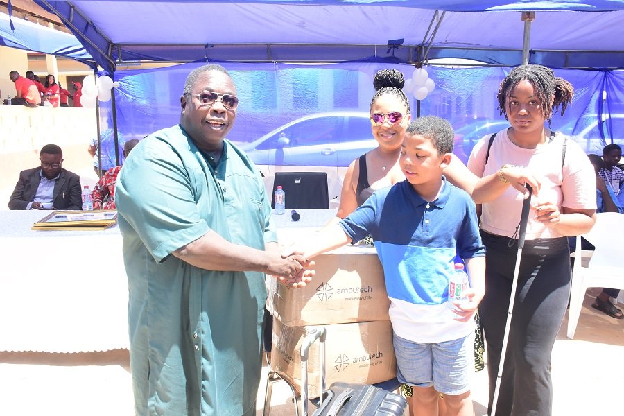 • Master Brayson Roberts (second from right) presenting boxes of white canes to Dr Peter Obeng-Asamoa Photo: Seth Osabukle